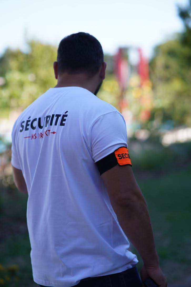 Agent MS Protect en tenue de gardiennage, t-shirt Sécurité et brassard, en surveillance sur un site extérieur